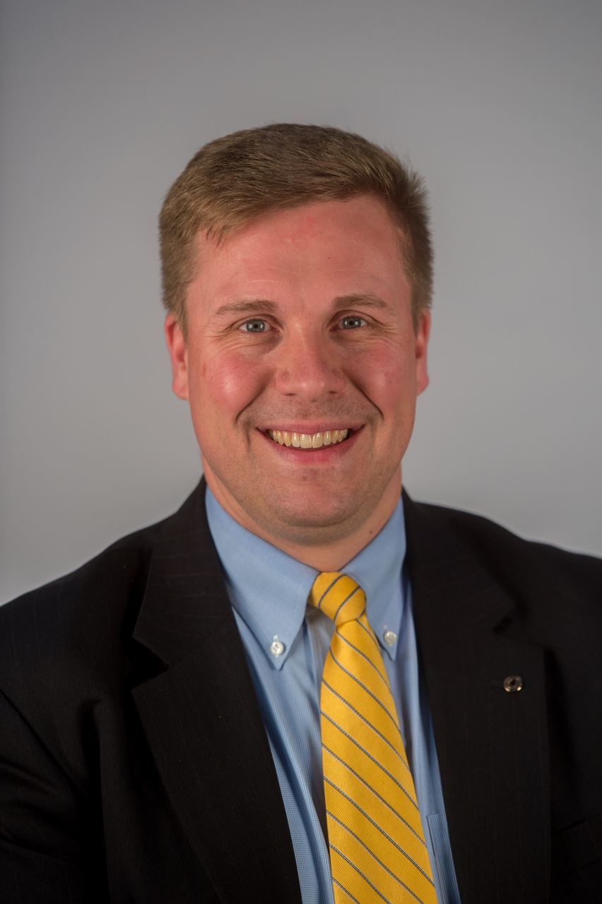 Headshot of white male, Matthew Davis, smiling with a suit on