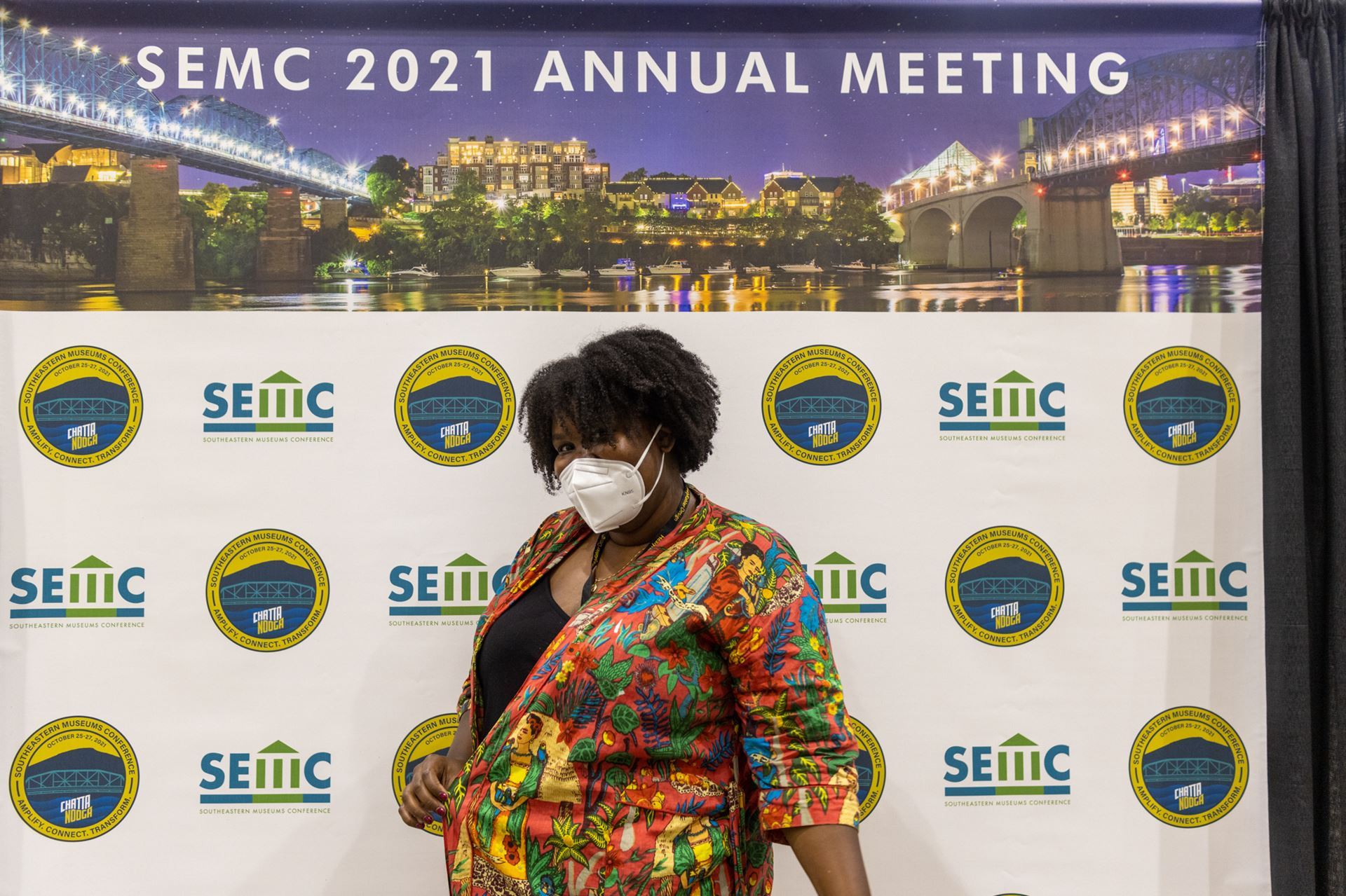 Medium shot of black female with curly brown hair, wearing a mask and multicolored blazer at the SEMC 2021 Annual Meeting